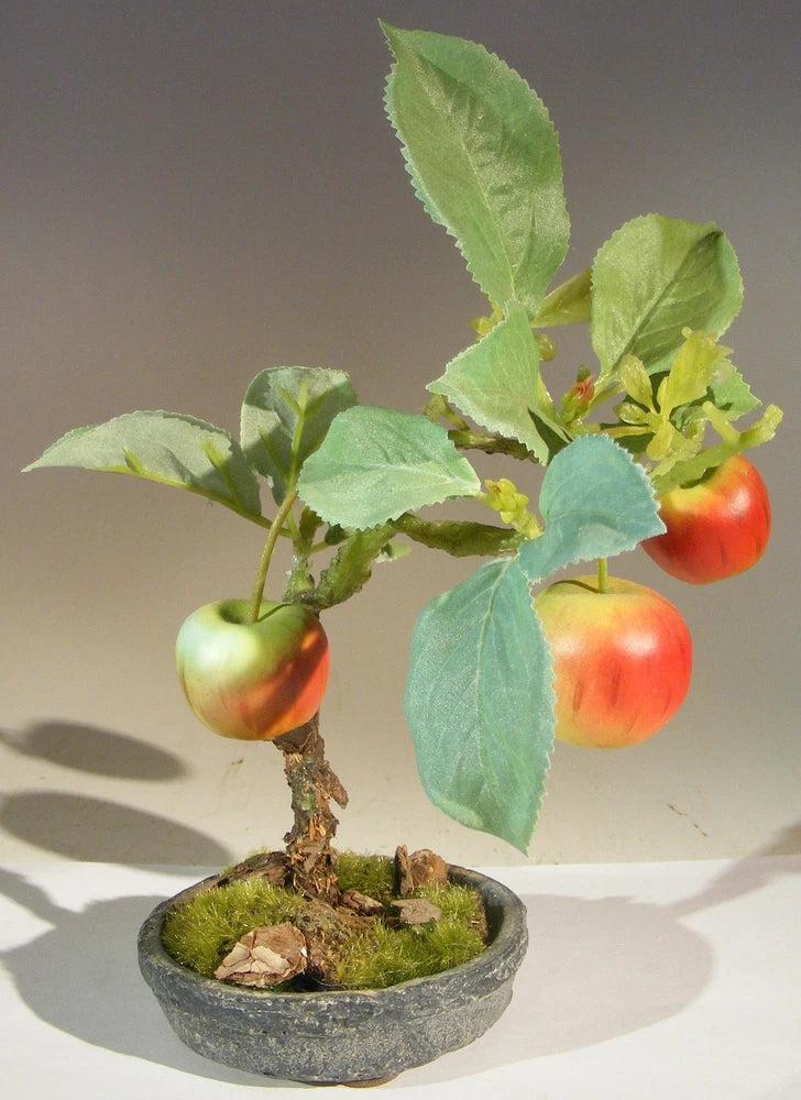 Artificial apple bonsai tree in round gray clay pot with green leaves and red apples