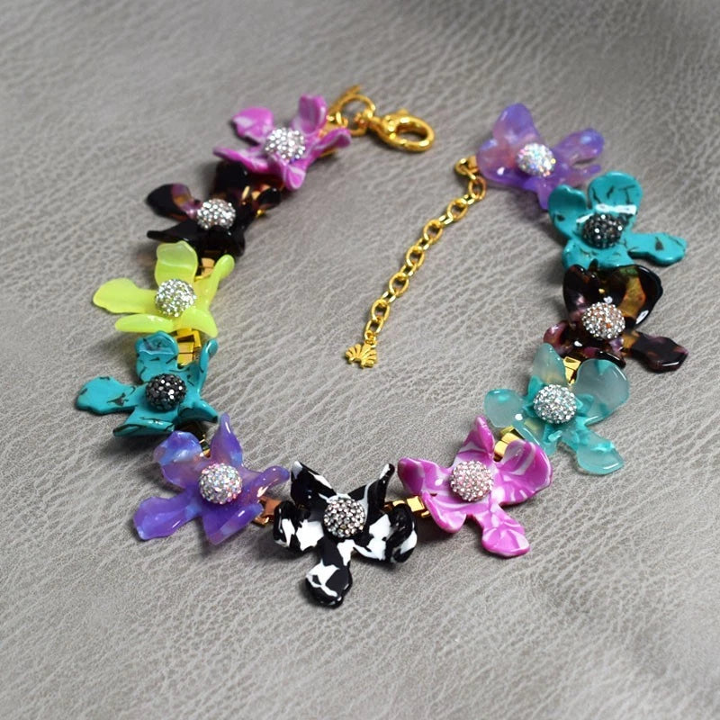 Colorful crystal flower collar necklace with black-and-silver centers, gold-tone clasp chain