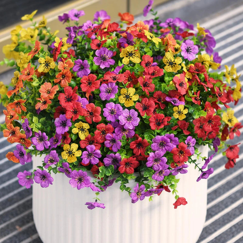 Artificial outdoor flower arrangement with multicolor small blossoms and green leaves