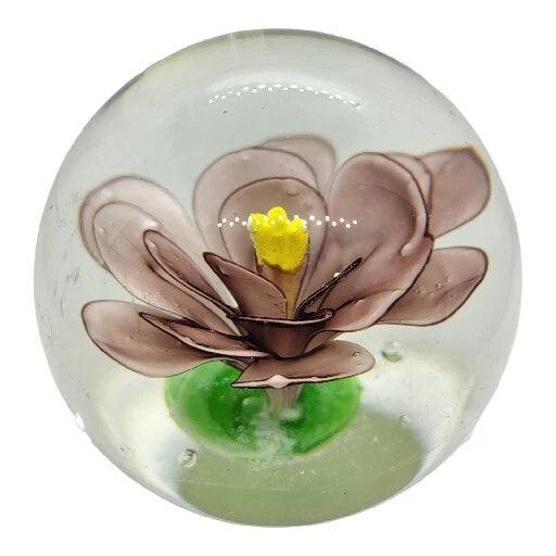 Round glass paperweight with pink water lily petals, green pad, and yellow flower center