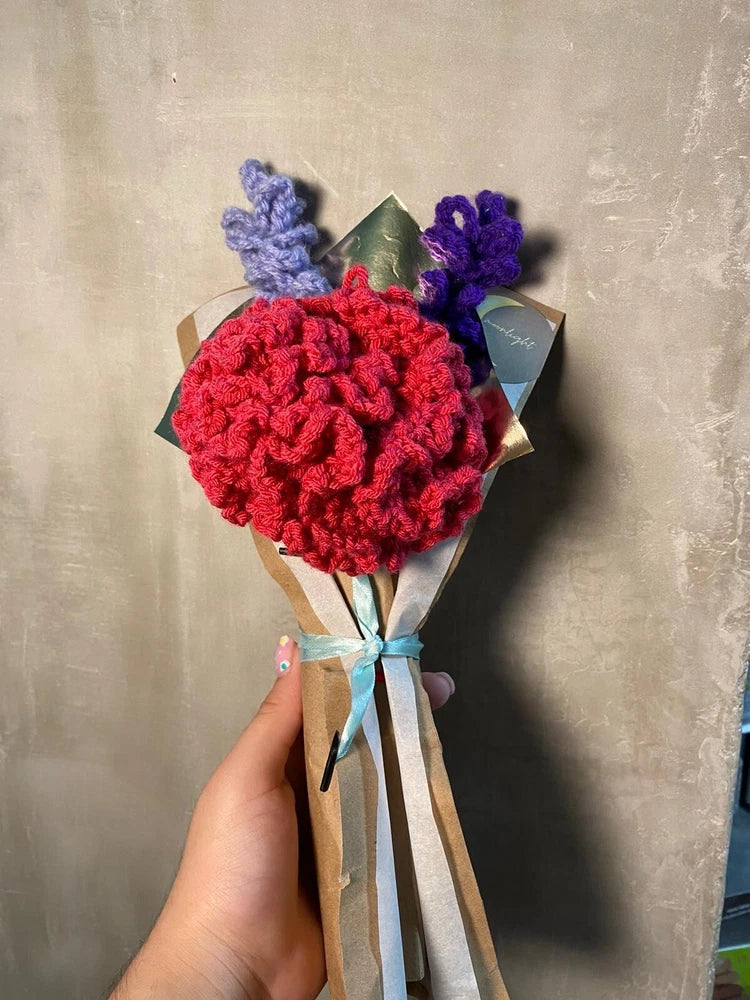 Handmade crochet flower bouquet with red blooms, purple flowers, and green leaves