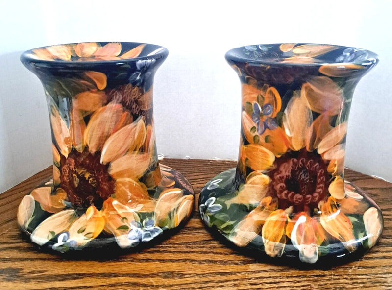 Pair of ceramic candle holders with handpainted sunflowers and painted bases, dark blue.