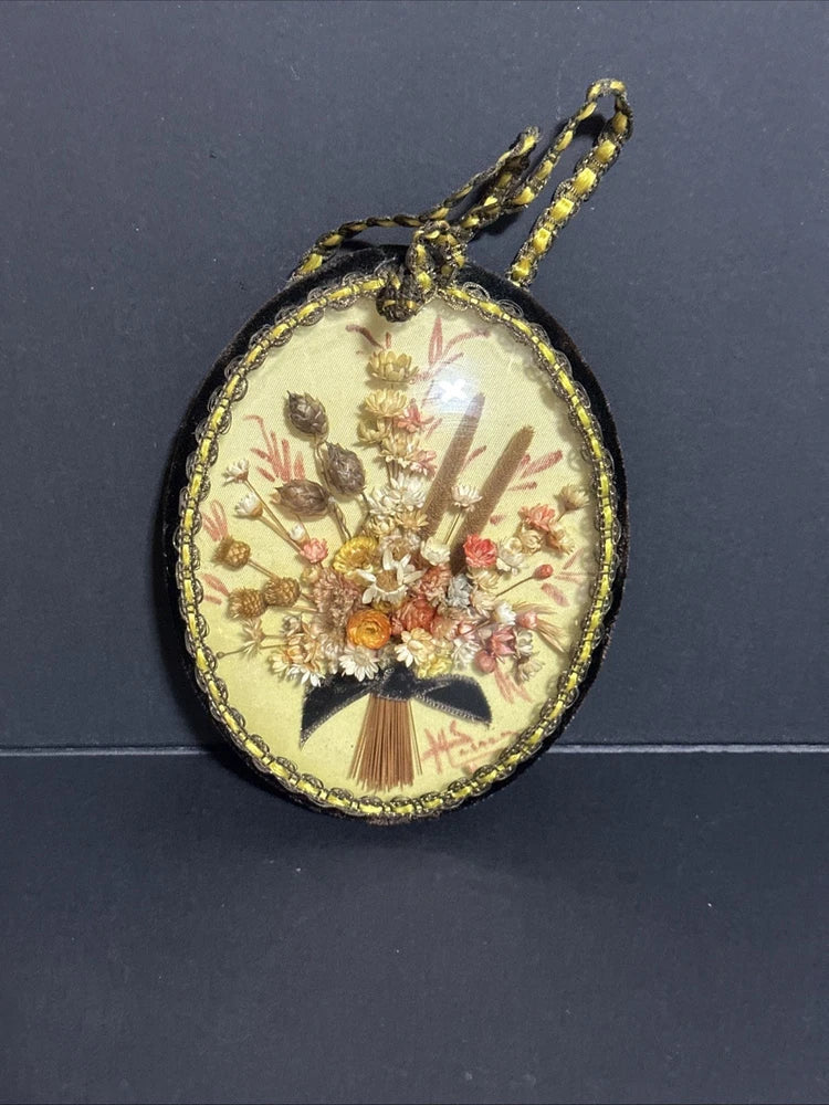 Round glass-framed dried flower ornament with gold beaded edge
