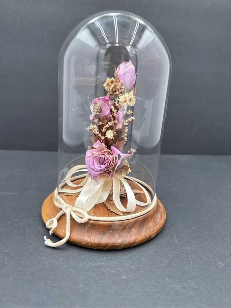 Glass dome with dried rose flowers on round wood base, tied with beige satin ribbon