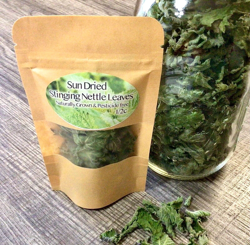 Sun-dried stinging nettle leaves in a kraft pouch with loose dried leaves