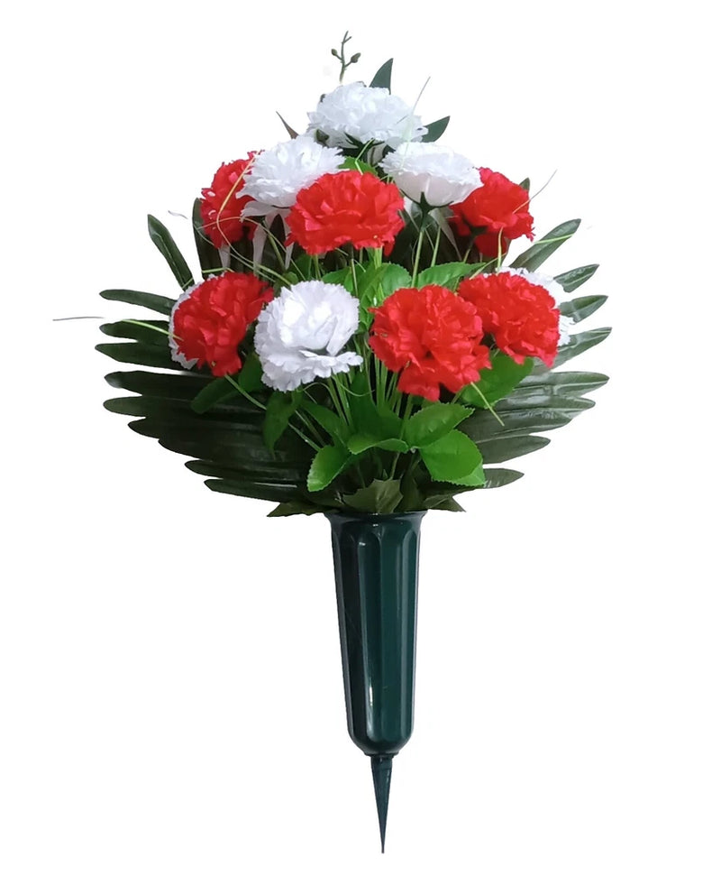 Grave silk carnation bouquet with red and white blooms, green leaves, in dark vase stake