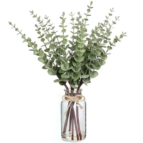 Artificial eucalyptus stems in clear glass vase with faux water and tied ribbon