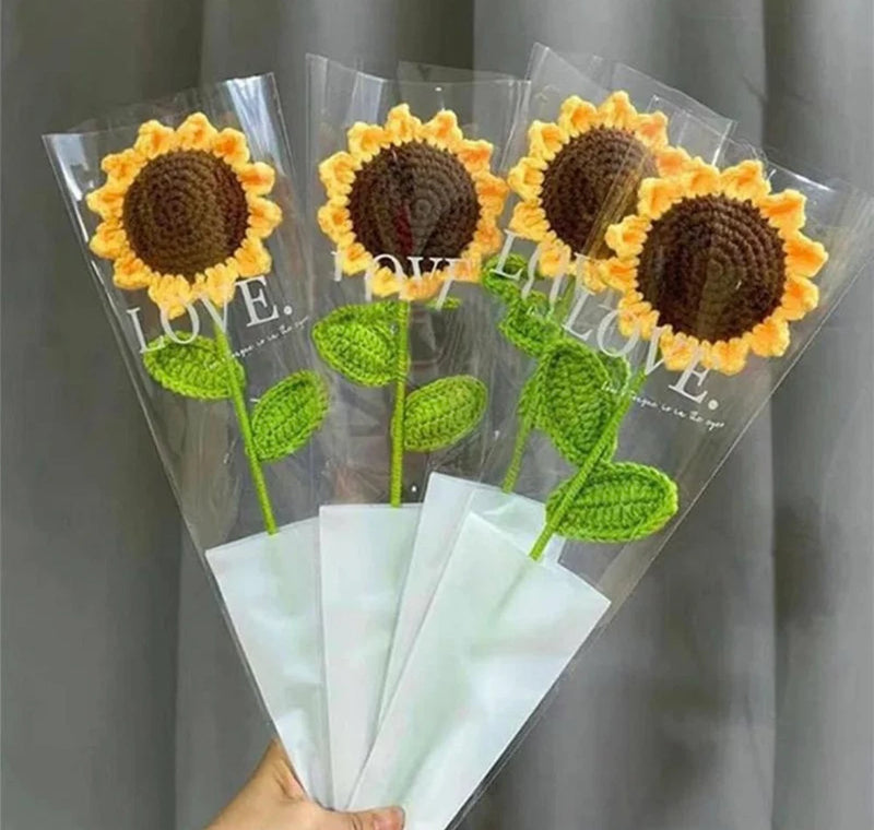 Hand-woven sunflower bouquet with yellow blooms and green leaves in clear wrap
