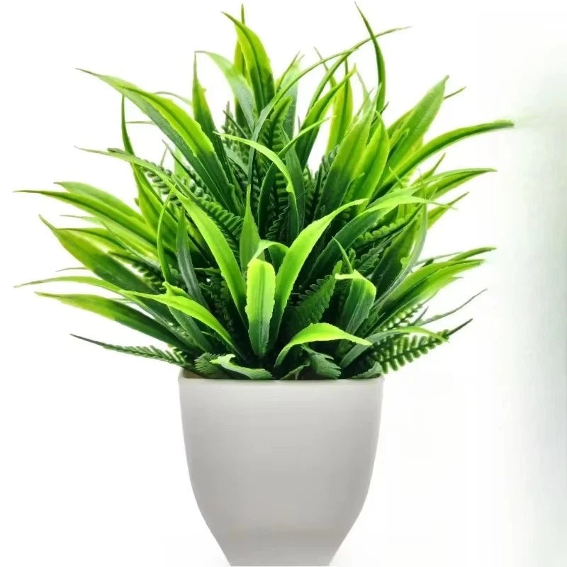 Artificial green grass plant with long blades in a white square pot