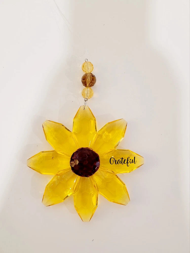 Yellow sunflower suncatcher ornament with dark center, hanging beads, and “Grateful” charm