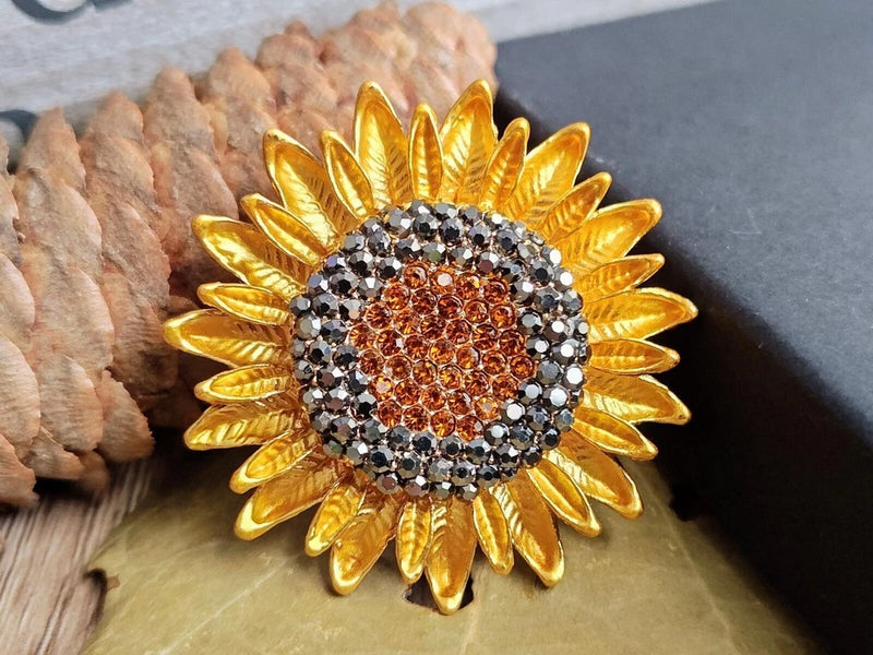 Gold-tone sunflower rhinestone brooch with amber and clear gem center, scalloped petals