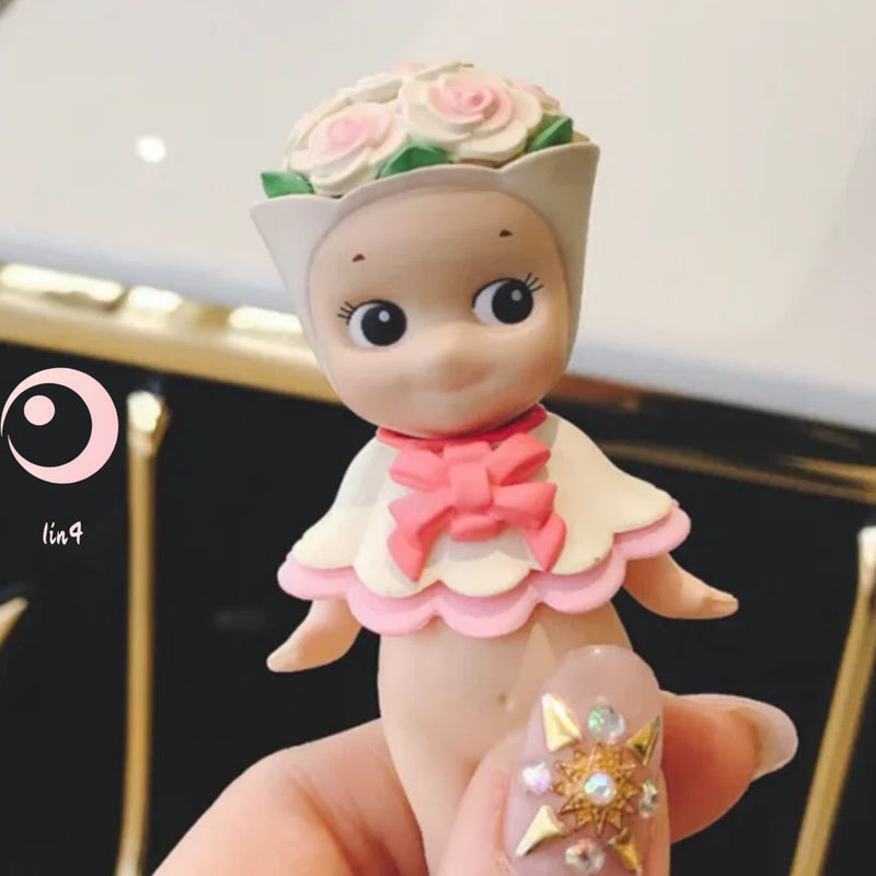Miniature doll figure with pink flower headpiece and white-pink dress