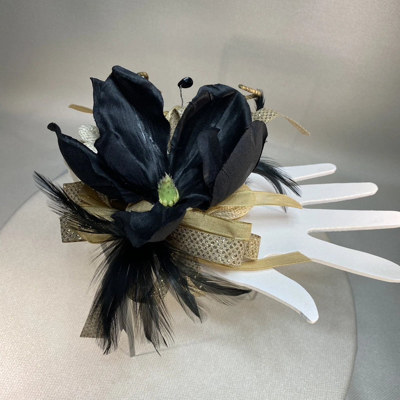 Black wrist corsage with glittering burlap wrap, faux pearls, and feather accents