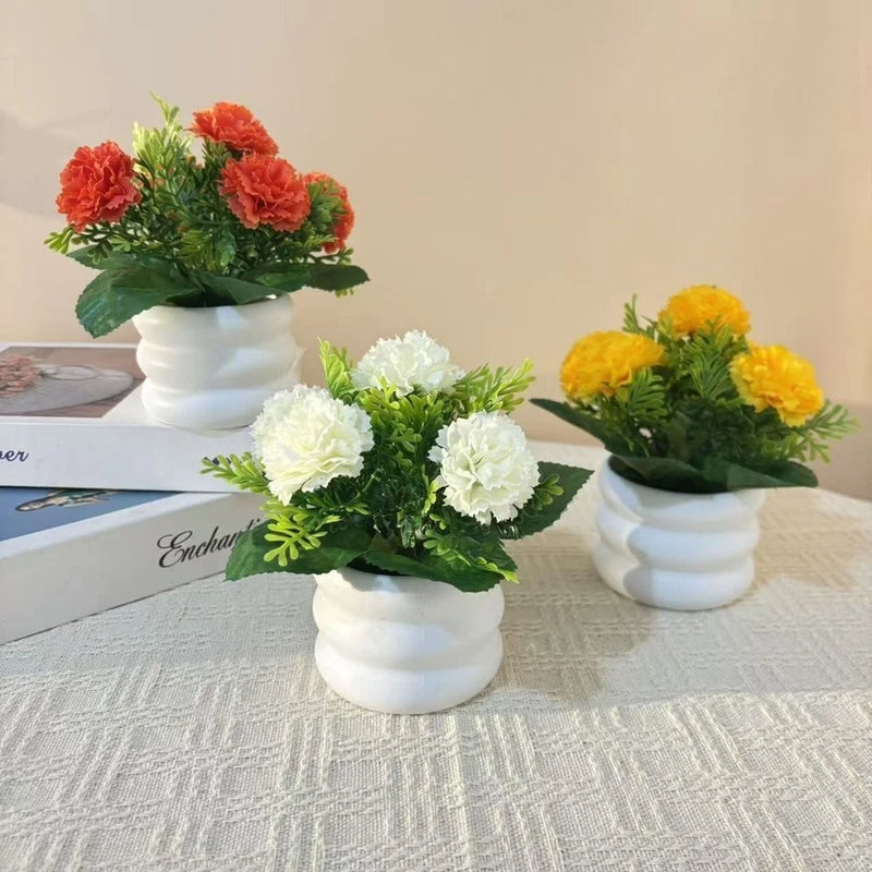 Artificial carnation plant set in white pots, orange white and yellow blooms with green leaves
