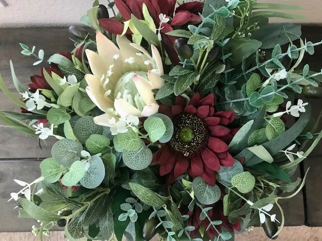 Mixed floral decor bouquet with burgundy and white flowers, green foliage, and sunflowers