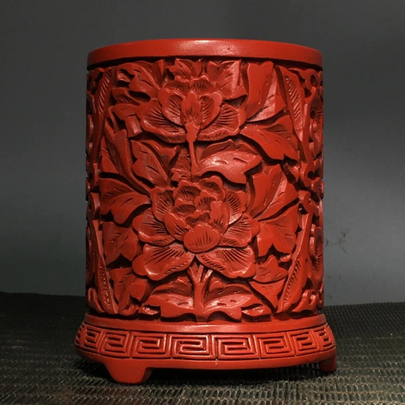Carved red lacquer brush pot with peony flower relief and decorative base
