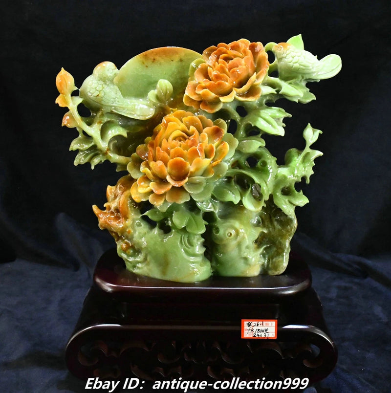 Carved green jade-look bird statue with peony flowers on dark wooden base