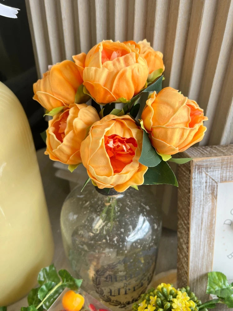 Orange faux peony silk flower bouquet in a clear glass vase