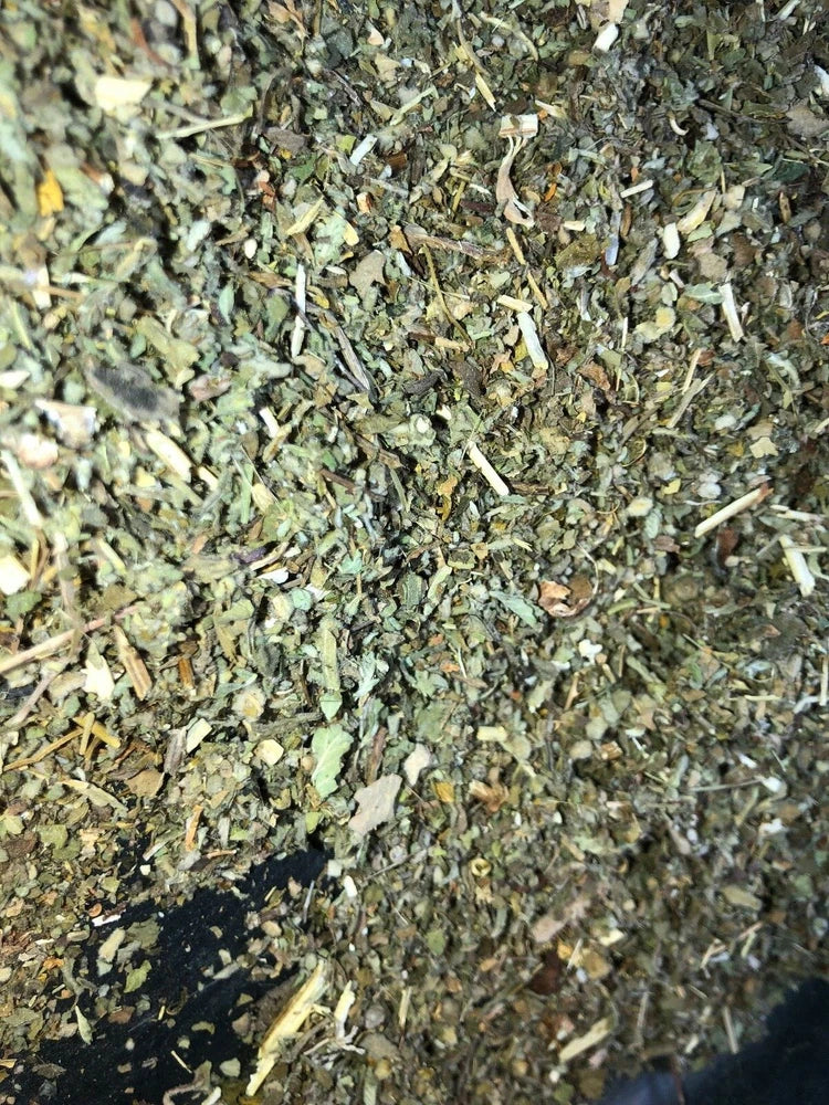 Dried herbal tea blend mix with green leaf pieces and light stems