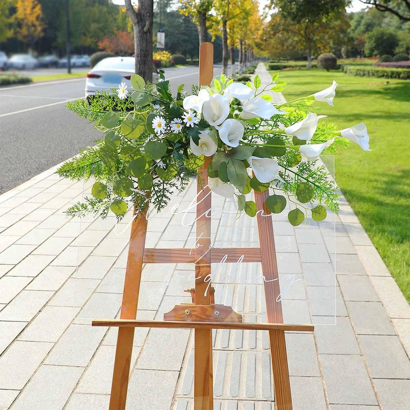 Artificial floral swag on wooden arch stand with white faux calla lilies and greenery