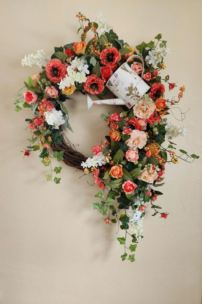 Spring flower wreath with red and white carnations, pink accents, and hanging ribbon