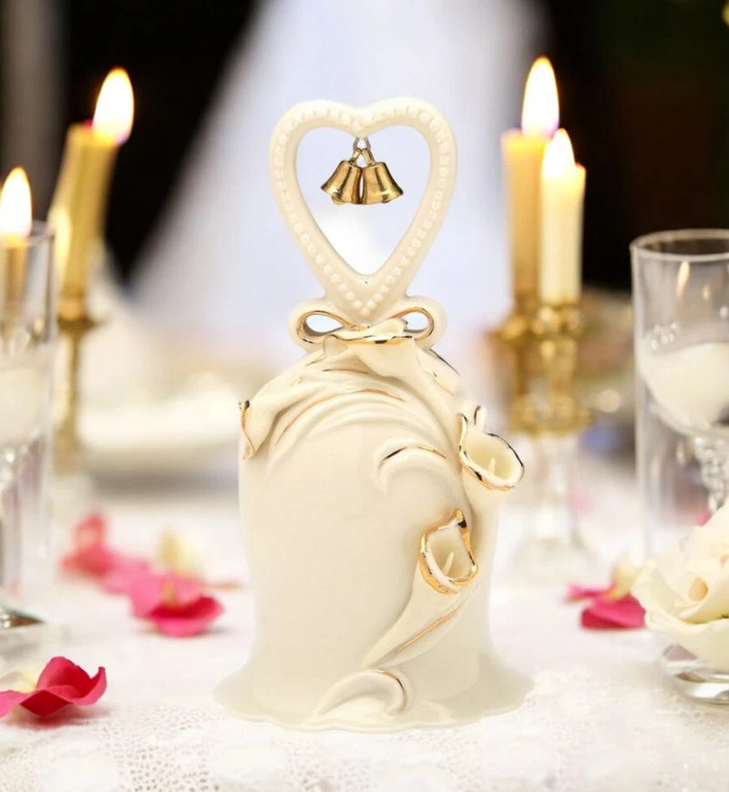 Ivory ceramic wedding bell with heart-shaped cutout and golden accents on ribbons