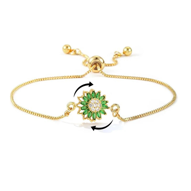 Gold-tone adjustable bracelet with rotating green flower rhinestone charm and ball links