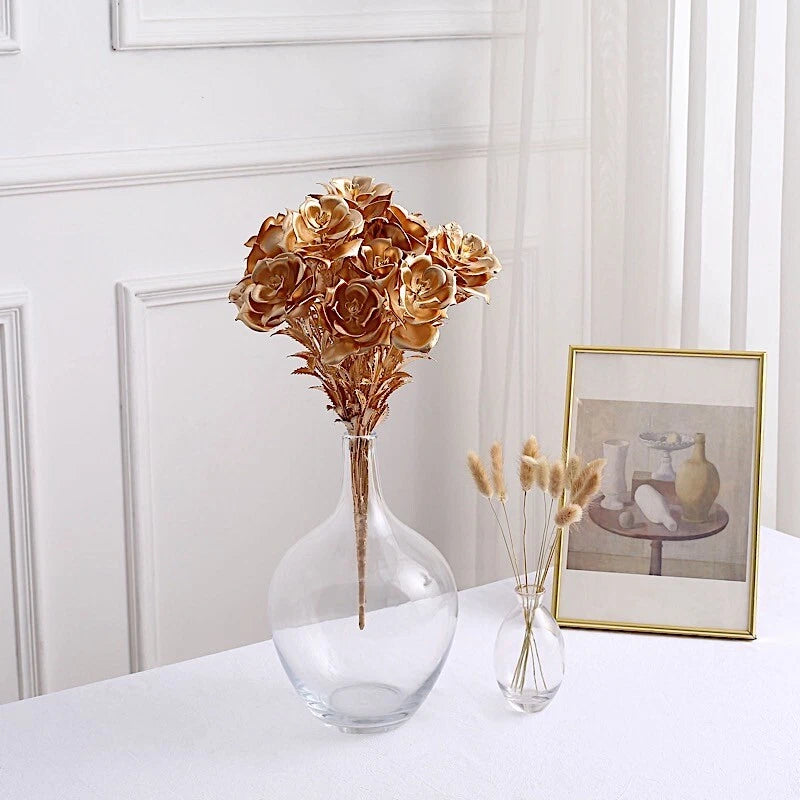 Artificial metallic gold rose bouquet in clear glass vase