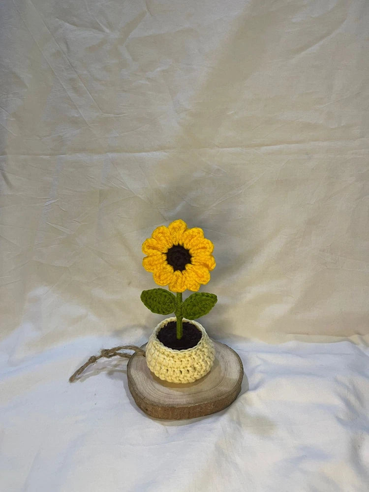 Faux sunflower in a yellow knit pot on a round wood base, standing decor