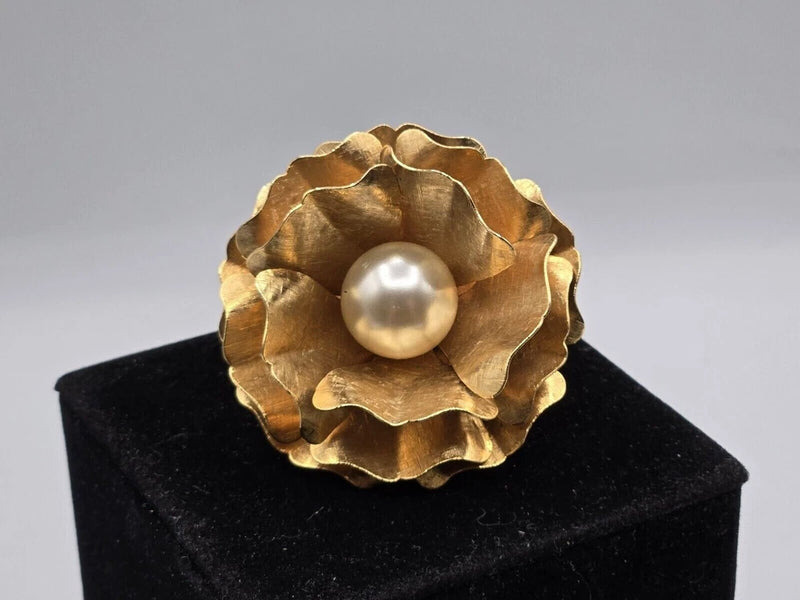 Gold-tone flower brooch with large scalloped petals and faux pearl center