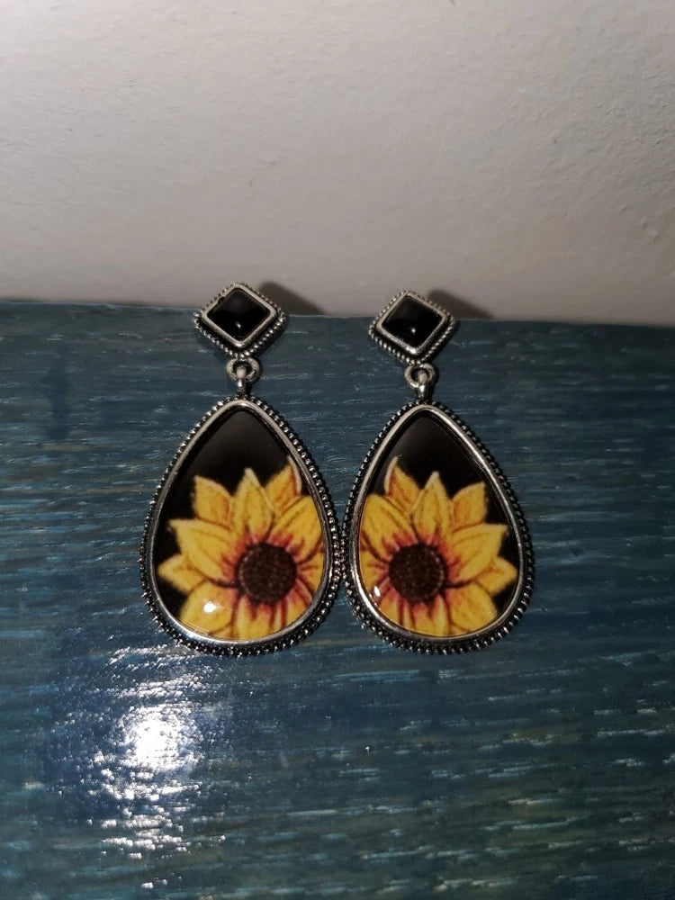 Black teardrop sunflower drop earrings with gold yellow petals and dark center, on hooks