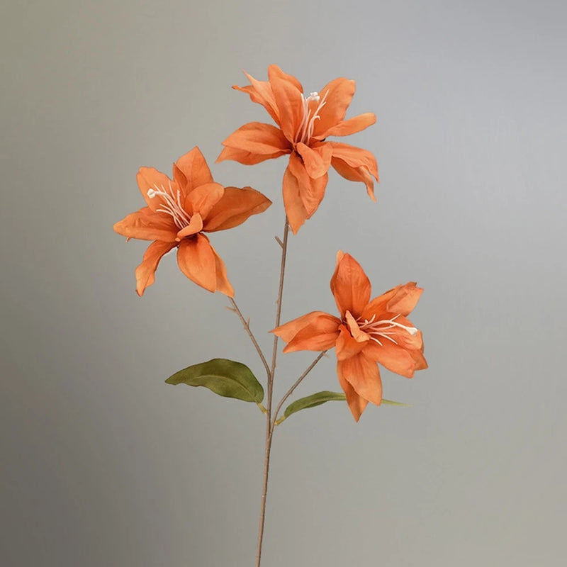 Artificial small lily flower spray with three orange blooms, stems, and green leaves