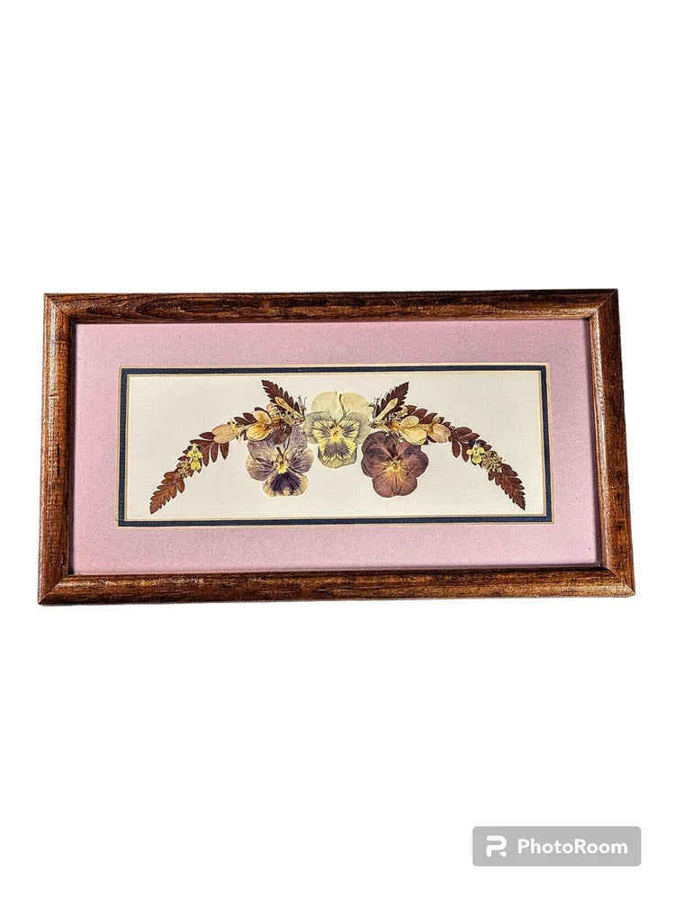 Framed dried flower art with pressed pansies and gold stems in brown frame