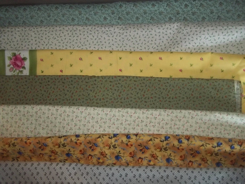 Cotton quilt fabric bundle with small calico flowers on green, yellow, and blue