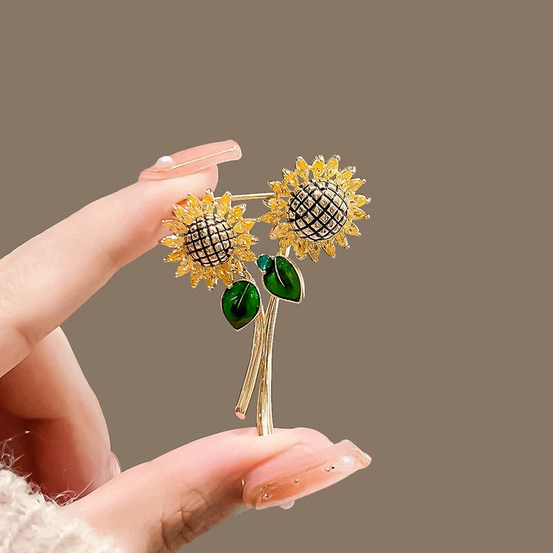 Gold-tone enamel sunflower brooch with crystal centers, green leaves, two-flower design