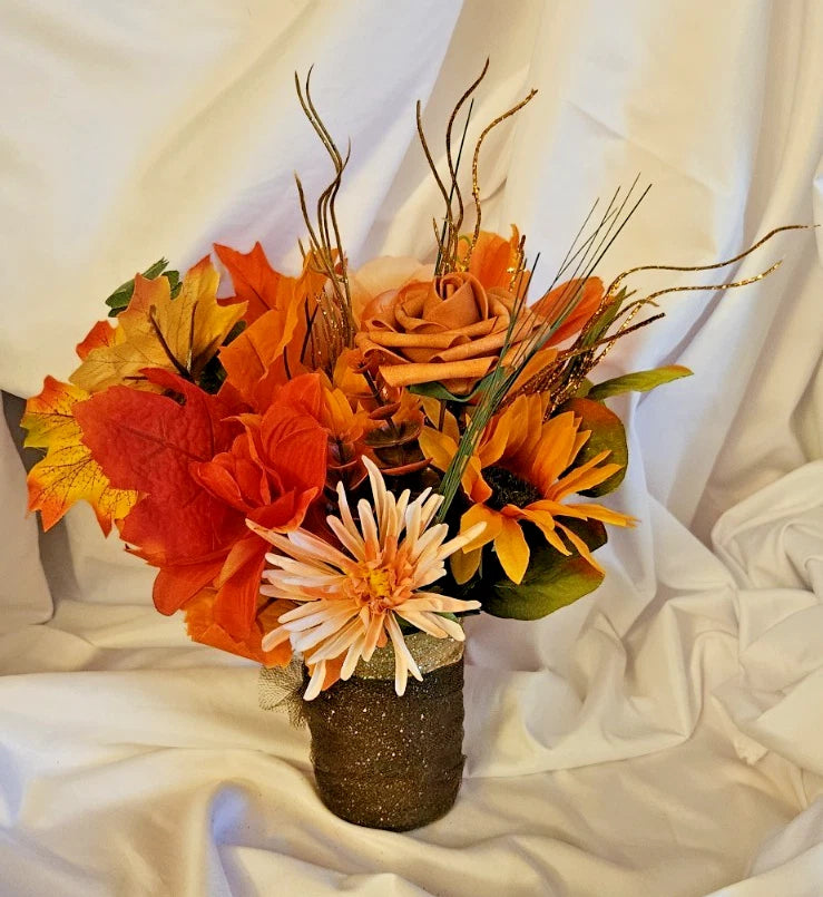 Artificial flower arrangement with orange and white blooms in a textured vase pot