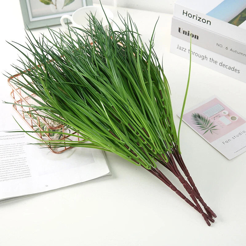 Artificial green grass plant bunch with multiple thin stems and narrow blades
