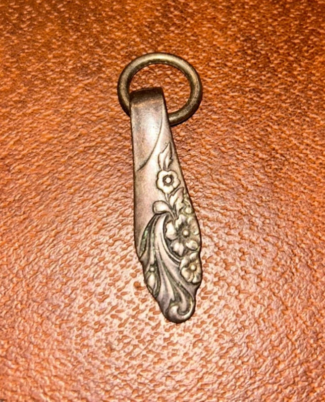 Silvertone floral keychain with etched tie-shaped charm and circular key ring