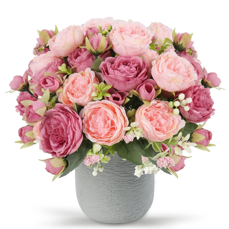 Pink faux peony silk flower bouquet with green leaves in gray ceramic vase