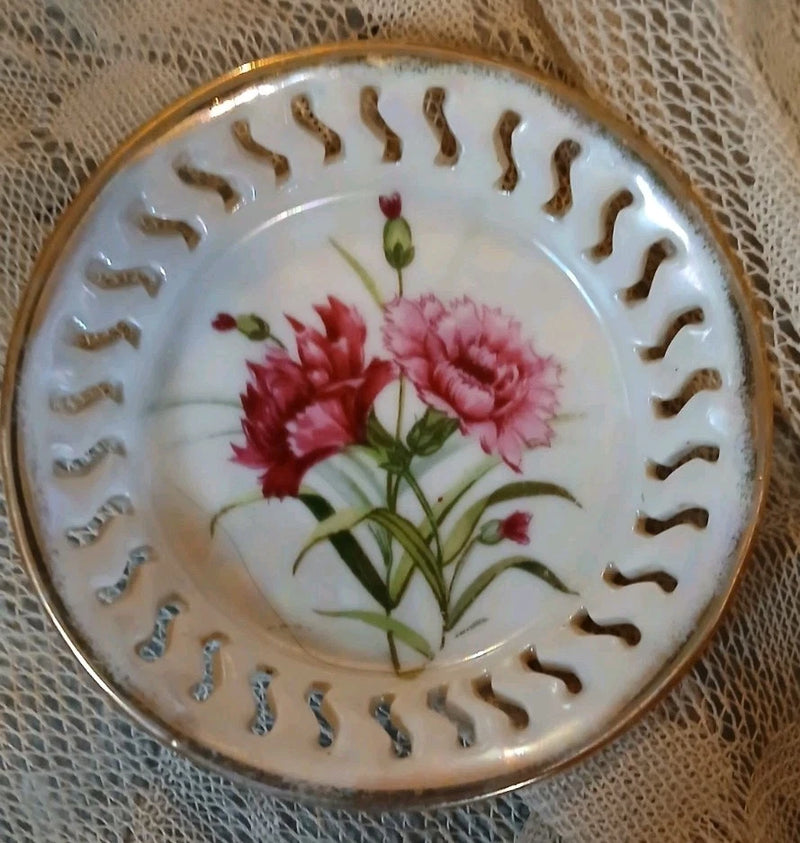 Round porcelain collector plate with pink carnation bouquet and gold rim trim