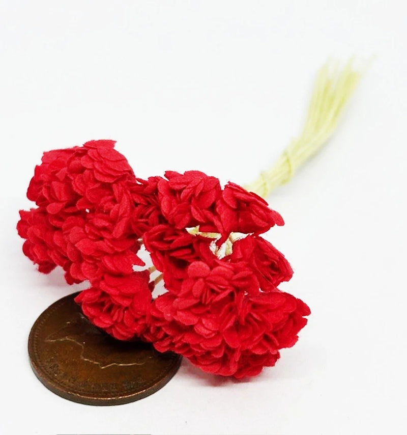 Bunch of red paper carnation flowers with curled petals and pale stems