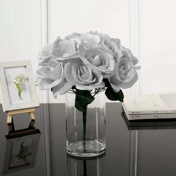 Artificial velvet rose bouquet with light gray blooms in a clear glass vase