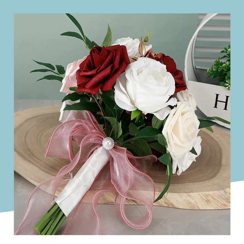 Faux rose hand bouquet with red and white blooms, green leaves, and pink ribbon bow