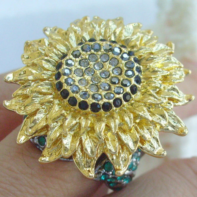 Gold-tone sunflower ring with black and clear rhinestone center, petal setting