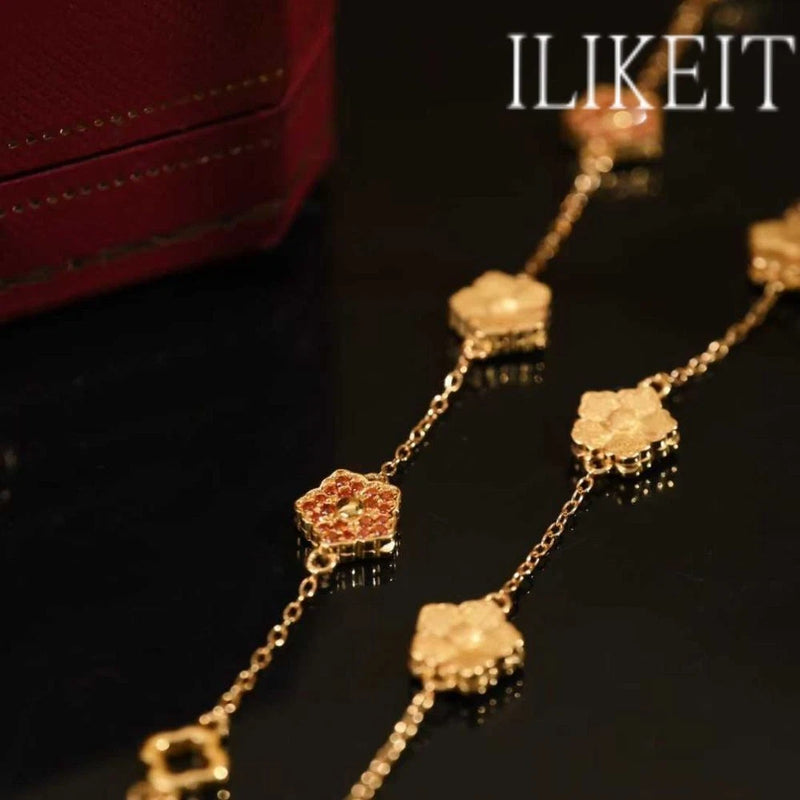 Gold-plated bracelet with peony-style flower charm, orange CZ, and filigree details.
