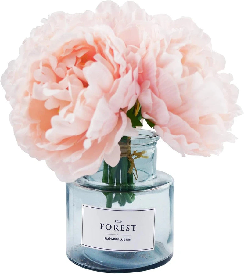 Pastel pink faux peony with green stem in clear glass jar