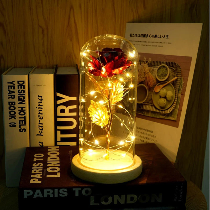 Glowing gold rose under clear glass dome with 24K-plated finish, gift display on base