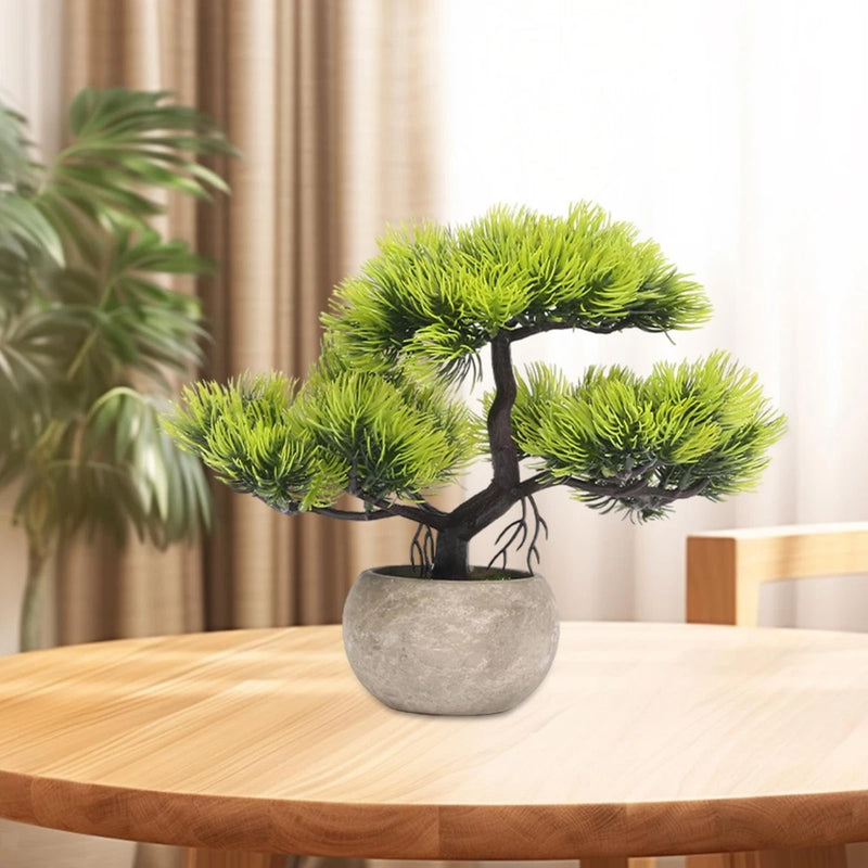Small artificial bonsai tree in grey stone-look pot with dense green foliage
