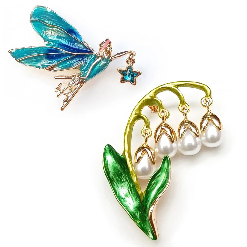 Green gold lily brooch pin with white pearl clusters, blue star charm, turquoise wing detail