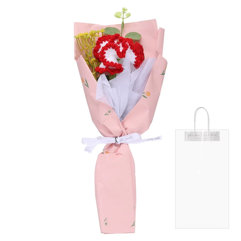 Handmade crochet carnation bouquet with red flowers and green leaves, wrapped in pink paper